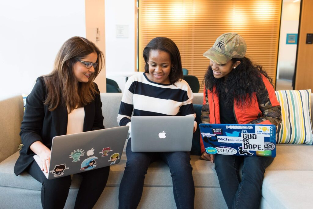 Women on computers smiling